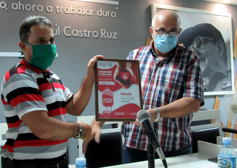 Carlos Rafael Miranda (a la derecha), coordinador nacional de los CDR, entrega al máximo dirigente de la organización en la provincia, Yosvani López, la condición de destacada en la jornada del donante de sangre. gerardo transporte 6