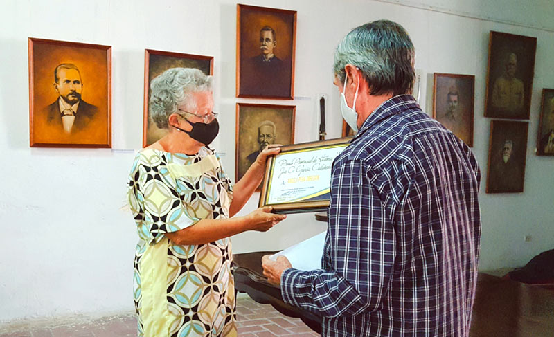 Ángela Peña recibe el Premio Provincial de Historia “José A. García Castañeda” de manos de Hiram Pérez, presidente de la filial de la Unhic en Holguín. Fotos de la autora Premio Historia Jose A 1